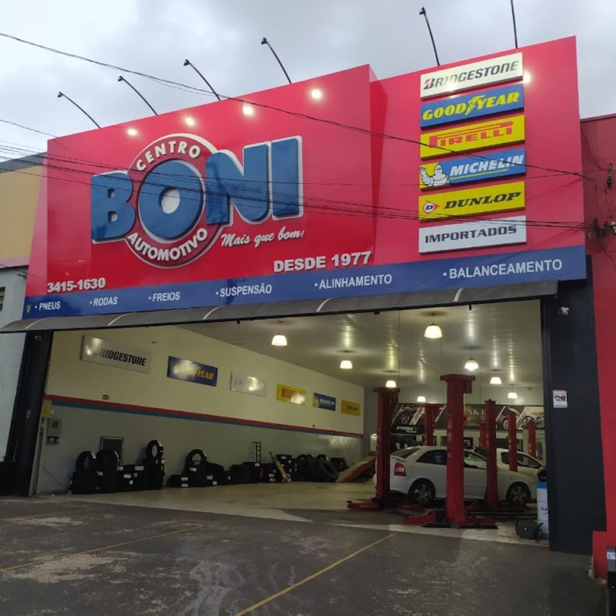 Fachada e pátio interno do Centro Automotivo Boni com elevadores e pneus